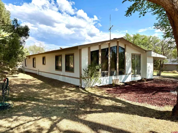 a view of a house with backyard and sitting area