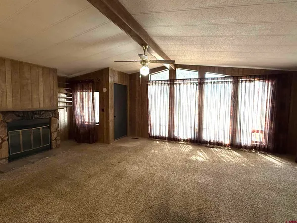 an empty room with windows and fireplace