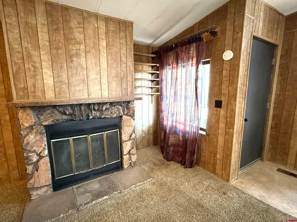a view of a livingroom with a fireplace and a window