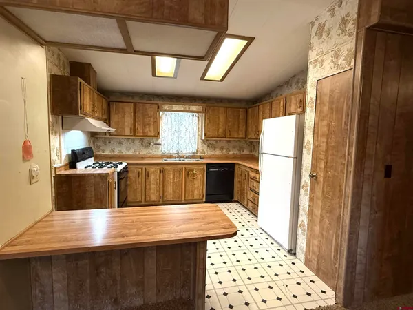 a kitchen with kitchen island a sink refrigerator and cabinets