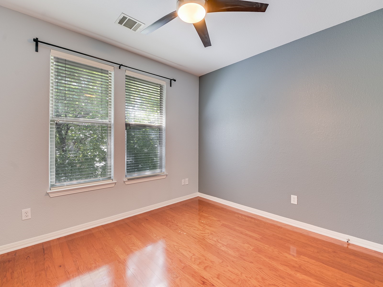 1115 Kinney Avenue, Unit 9 Austin, TX 78704 - Photo 12 of 19 Empty room featuring visible vents, wood finished floors, a ceiling fan, and baseboards