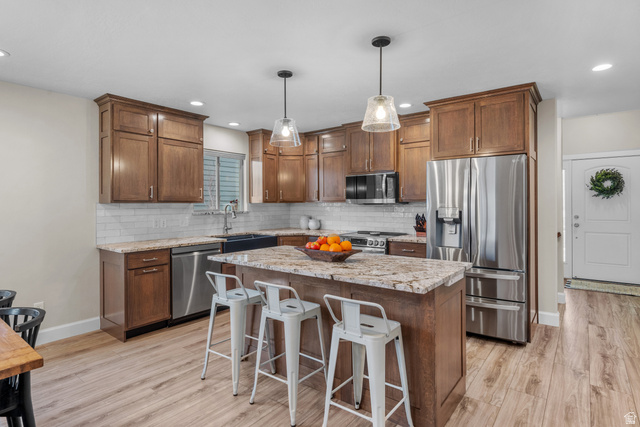 1896 West 800 North Mapleton, UT 84663 - Photo 8 of 55 Kitchen with stainless steel appliances, a breakfast bar area, light stone countertops, and a center island