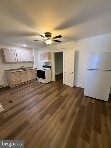 a view of a kitchen with a sink and a refrigerator
