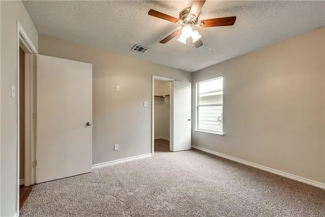 a view of a big room with chandelier fan and windows