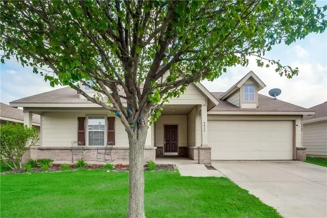 a front view of a house with a garden and yard