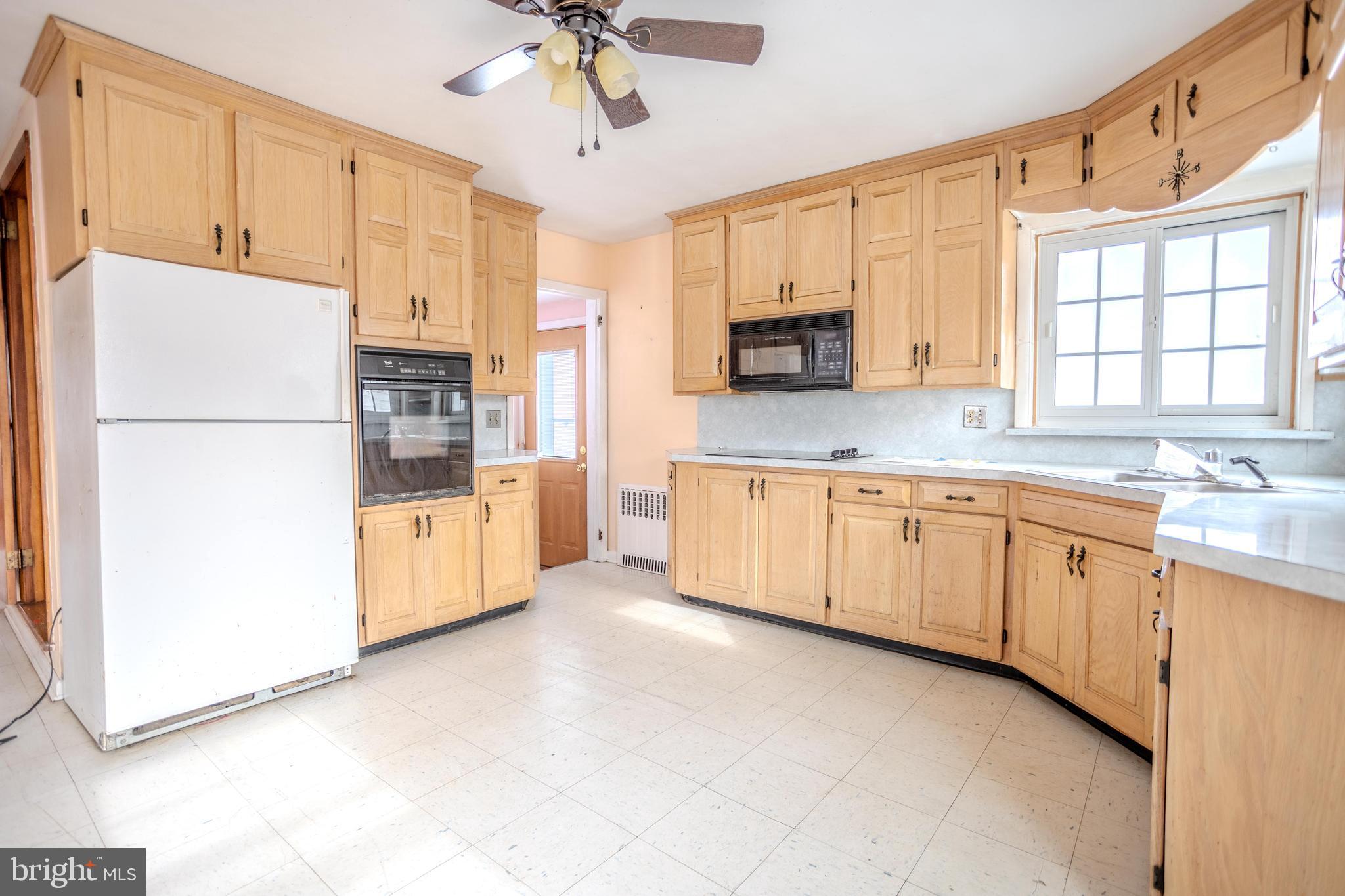 241 Wagner Road Chambersburg, PA 17202 - Photo 17 of 37 a kitchen with granite countertop a refrigerator a sink a stove and white cabinets