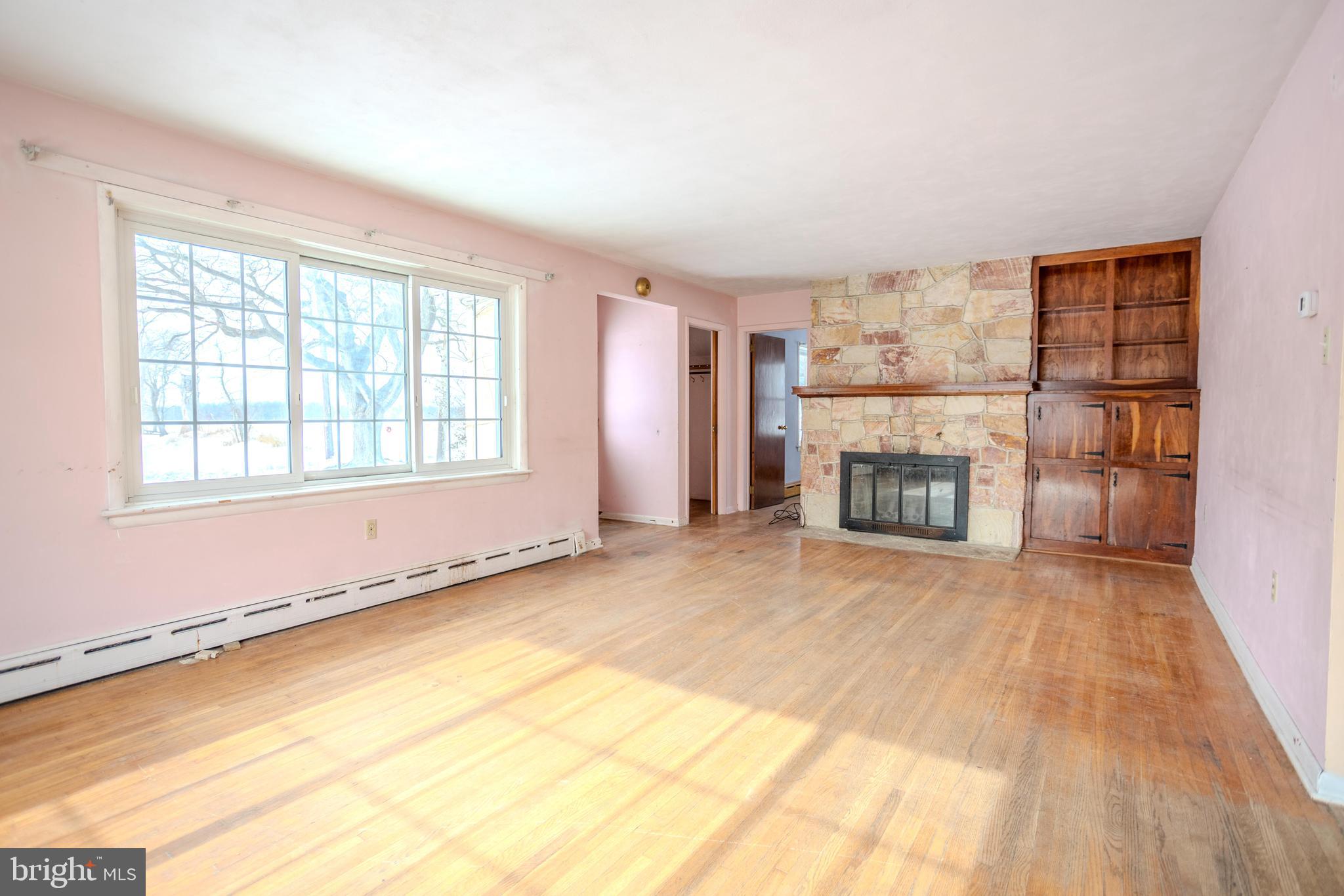 241 Wagner Road Chambersburg, PA 17202 - Photo 7 of 37 wooden floor fireplace and windows in an empty room