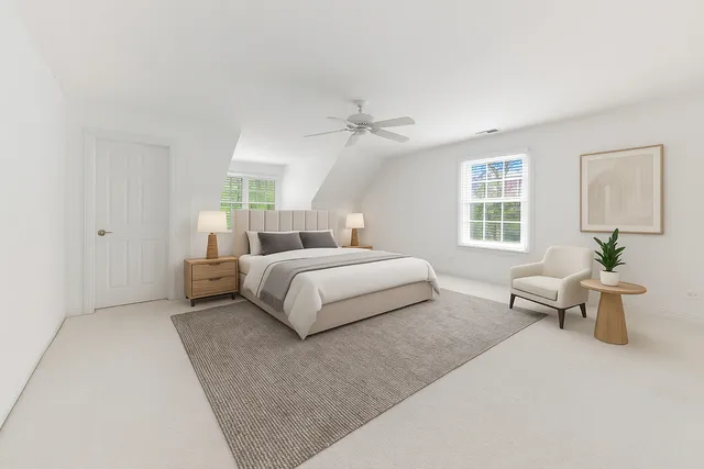 a bedroom with a large bed a chandelier and a couch