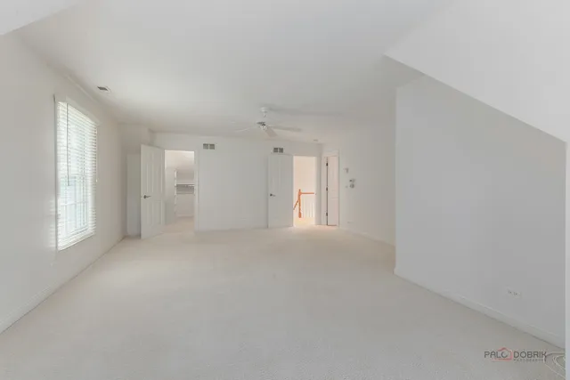 a view of empty room with windows and refrigerator
