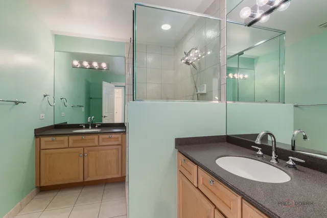 a bathroom with a granite countertop sink a mirror and a shower