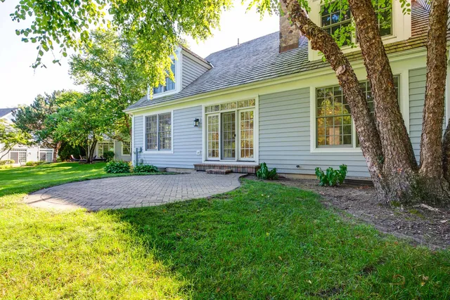 a front view of a house with a yard and green space
