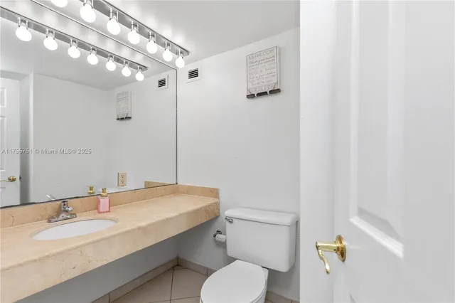 a bathroom with a granite countertop sink a toilet a mirror a vanity and shower