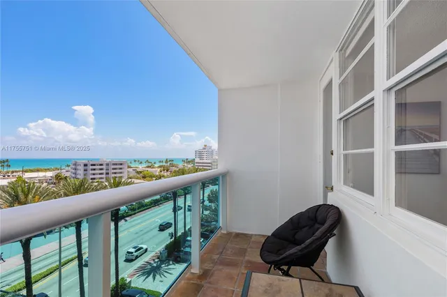 a view of a balcony with furniture and a potted plant
