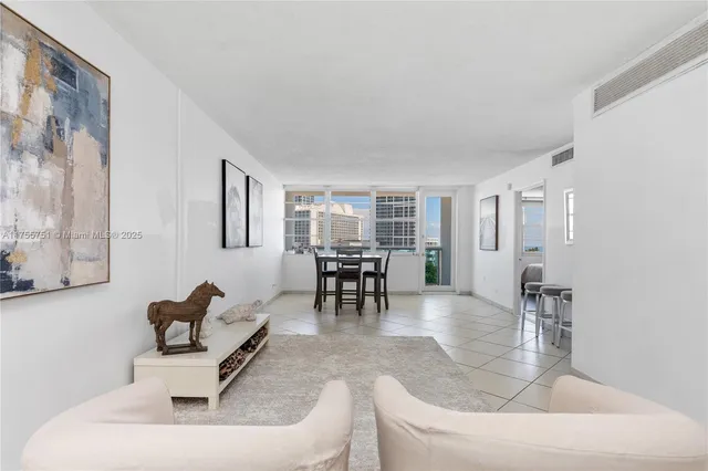 a living room with furniture and a dining table with kitchen view
