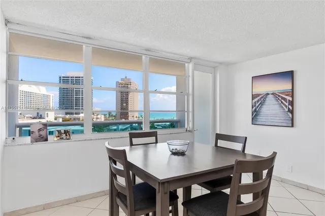 a dining room with furniture and a large window