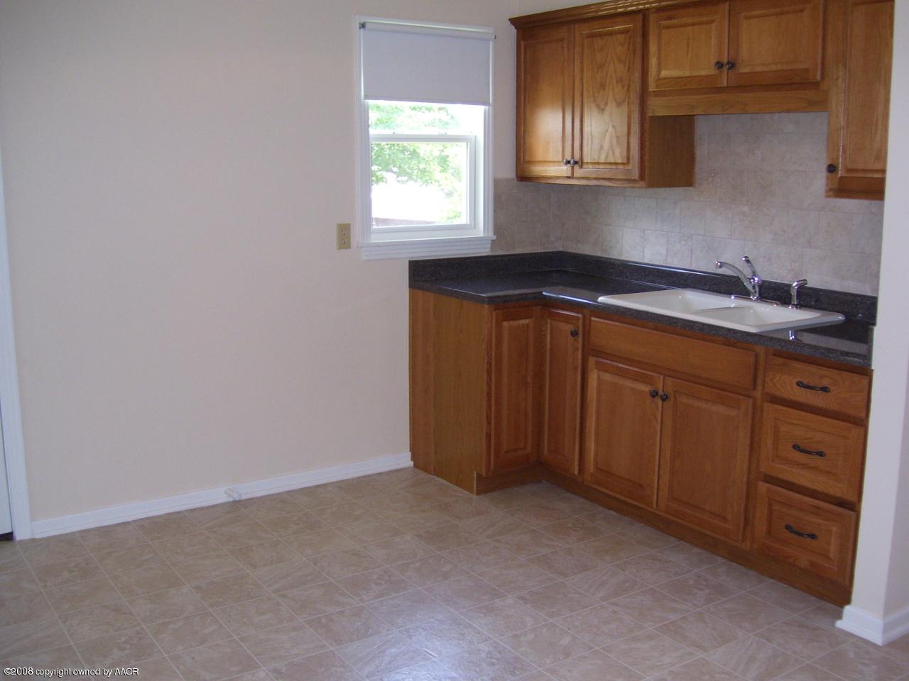 4641 Parker Street Amarillo, TX 79110 - Photo 5 of 8 a kitchen with cabinets a sink and dishwasher