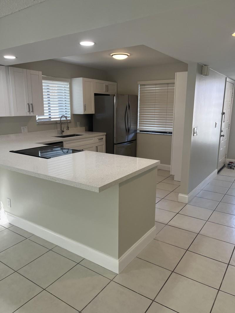 280 Racquet Club Road, Unit 206 Weston, FL 33326 - Photo 2 of 6 a large kitchen with kitchen island granite countertop a refrigerator a sink and a stove