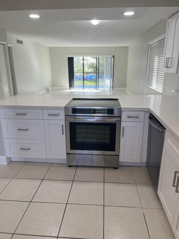 280 Racquet Club Road, Unit 206 Weston, FL 33326 - Photo 3 of 6 a kitchen with granite countertop a stove a sink and a microwave