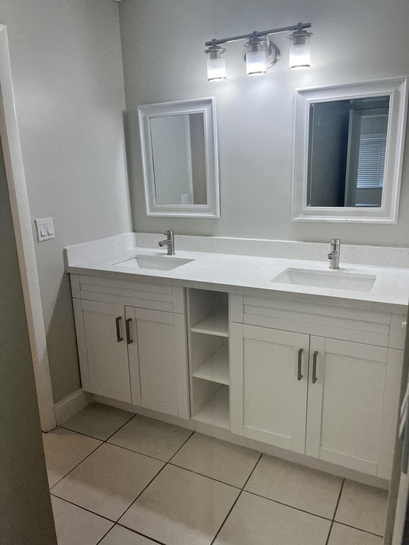 280 Racquet Club Road, Unit 206 Weston, FL 33326 - Photo 5 of 6 a bathroom with a double vanity sink and mirror