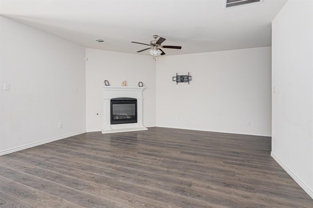 1500 Elizabeth Street Anna, TX 75409 - Photo 7 of 25 a view of a livingroom with wooden floor and a ceiling fan