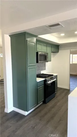 a large kitchen with stainless steel appliances granite countertop a granite counter tops and a wooden floor