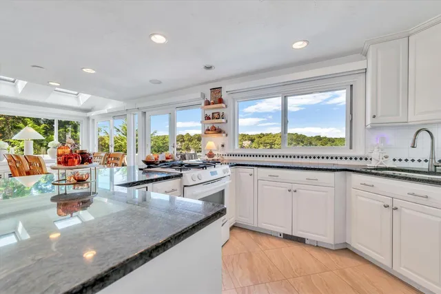 a kitchen with stainless steel appliances granite countertop a refrigerator and a sink