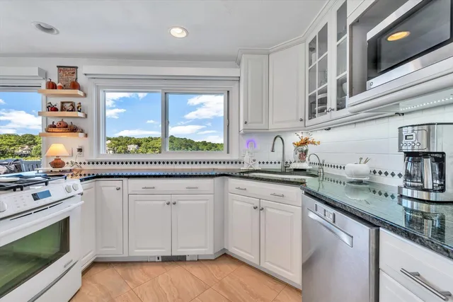 a living room with furniture a large window and wooden floor