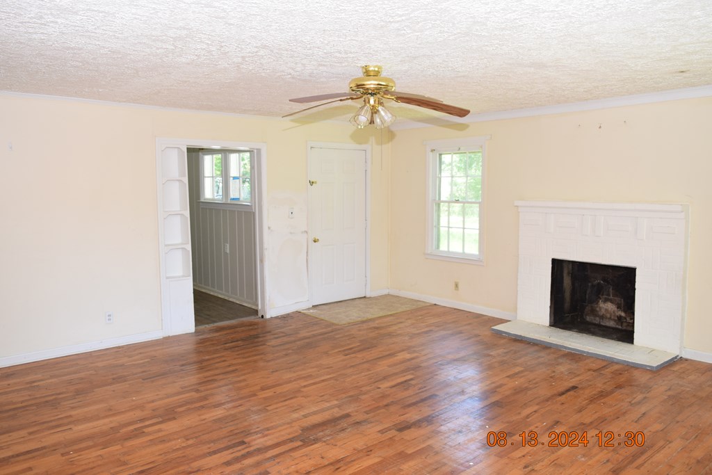 511 Chafin Drive Manchester, GA 31816 - Photo 3 of 16 a view of empty room with wooden floor and fireplace