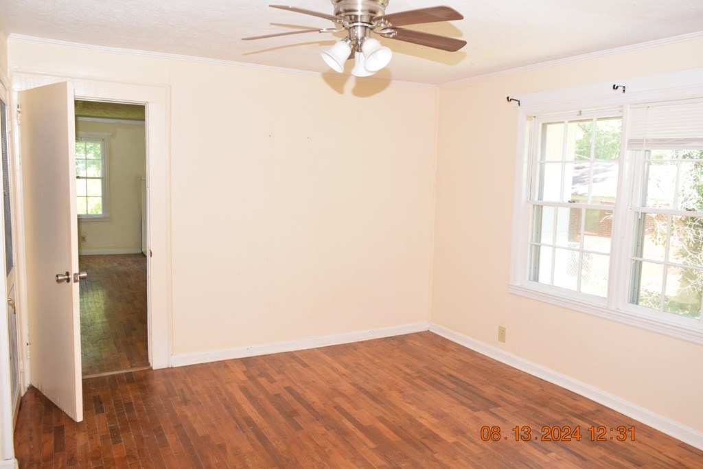 511 Chafin Drive Manchester, GA 31816 - Photo 8 of 16 an empty room with wooden floor fan and windows