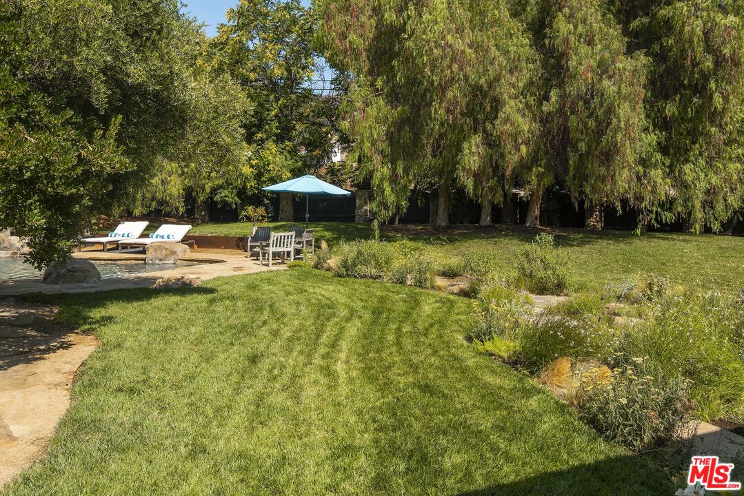 2251 Cold Canyon Road Calabasas, CA 91302 - Photo 35 of 47 a backyard of a house with table and chairs