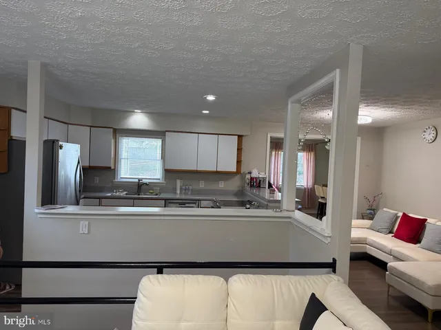 a kitchen with stainless steel appliances granite countertop a sink refrigerator and cabinets