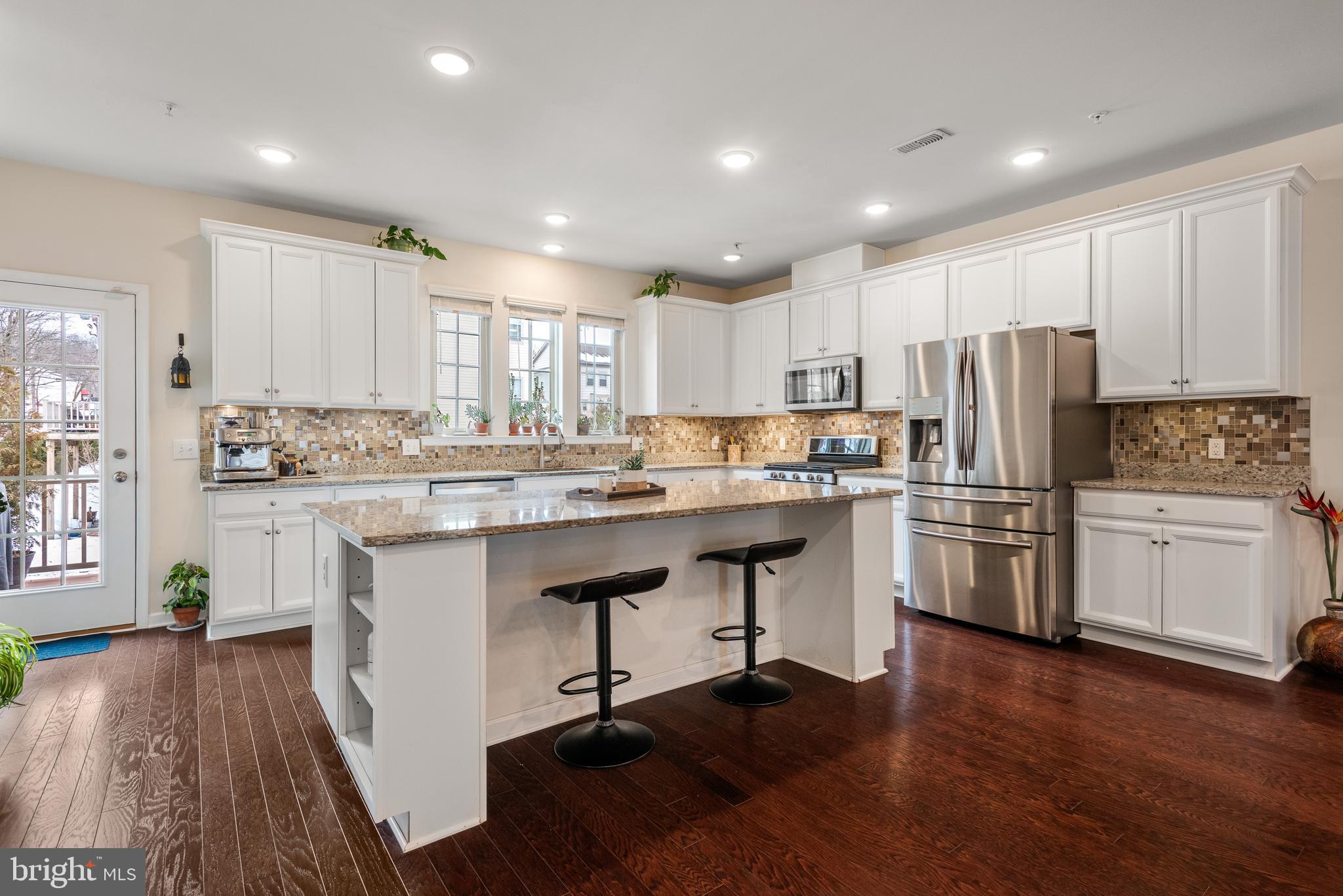 35 Addison Lane Malvern, PA 19355 - Photo 12 of 42 a kitchen with a refrigerator a sink dishwasher with a dining table and chairs