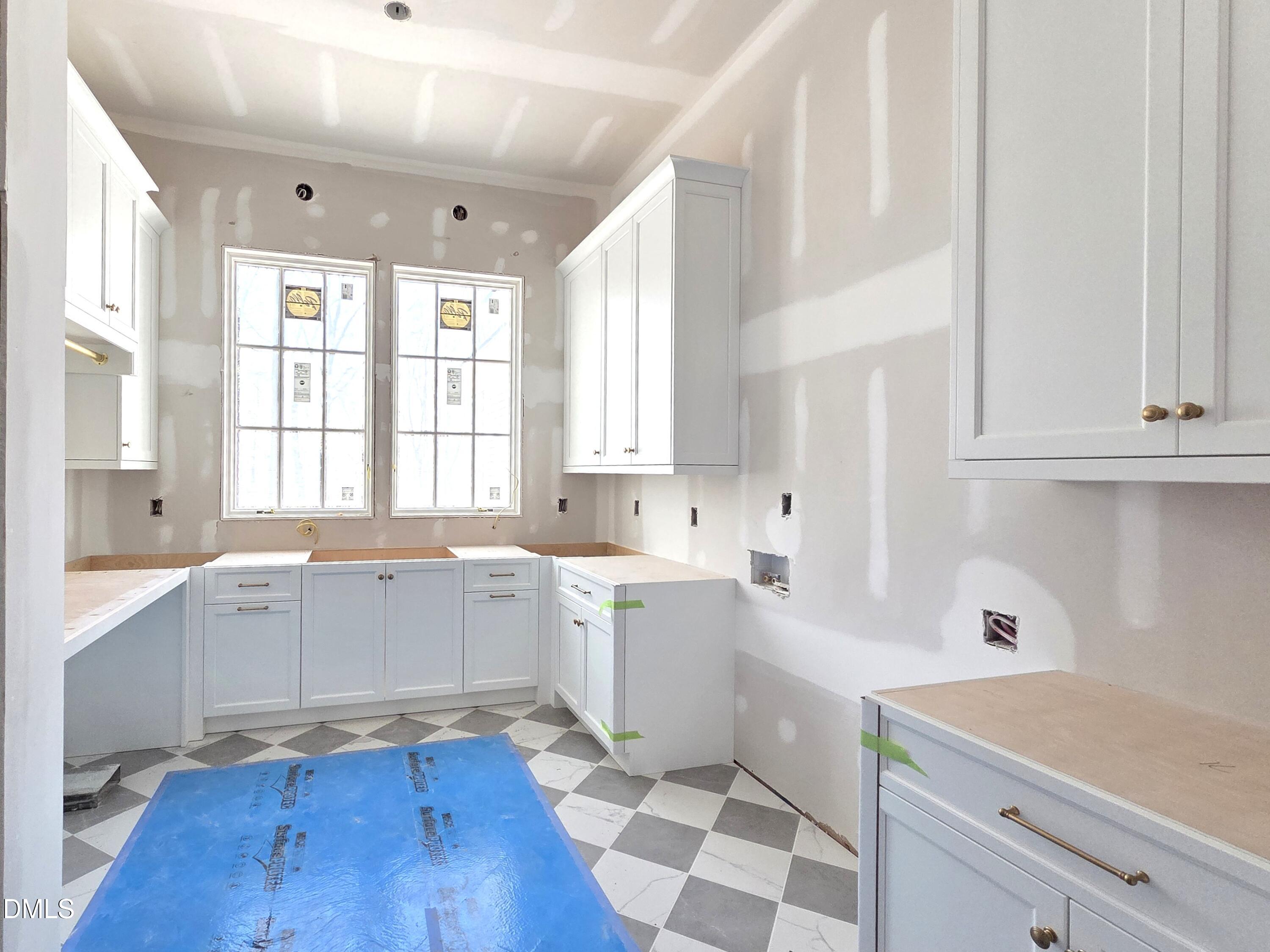 6477 Sanctuary Falls Drive Raleigh, NC 27614 - Photo 26 of 49 a large white kitchen with a stove a sink and dishwasher with wooden floor