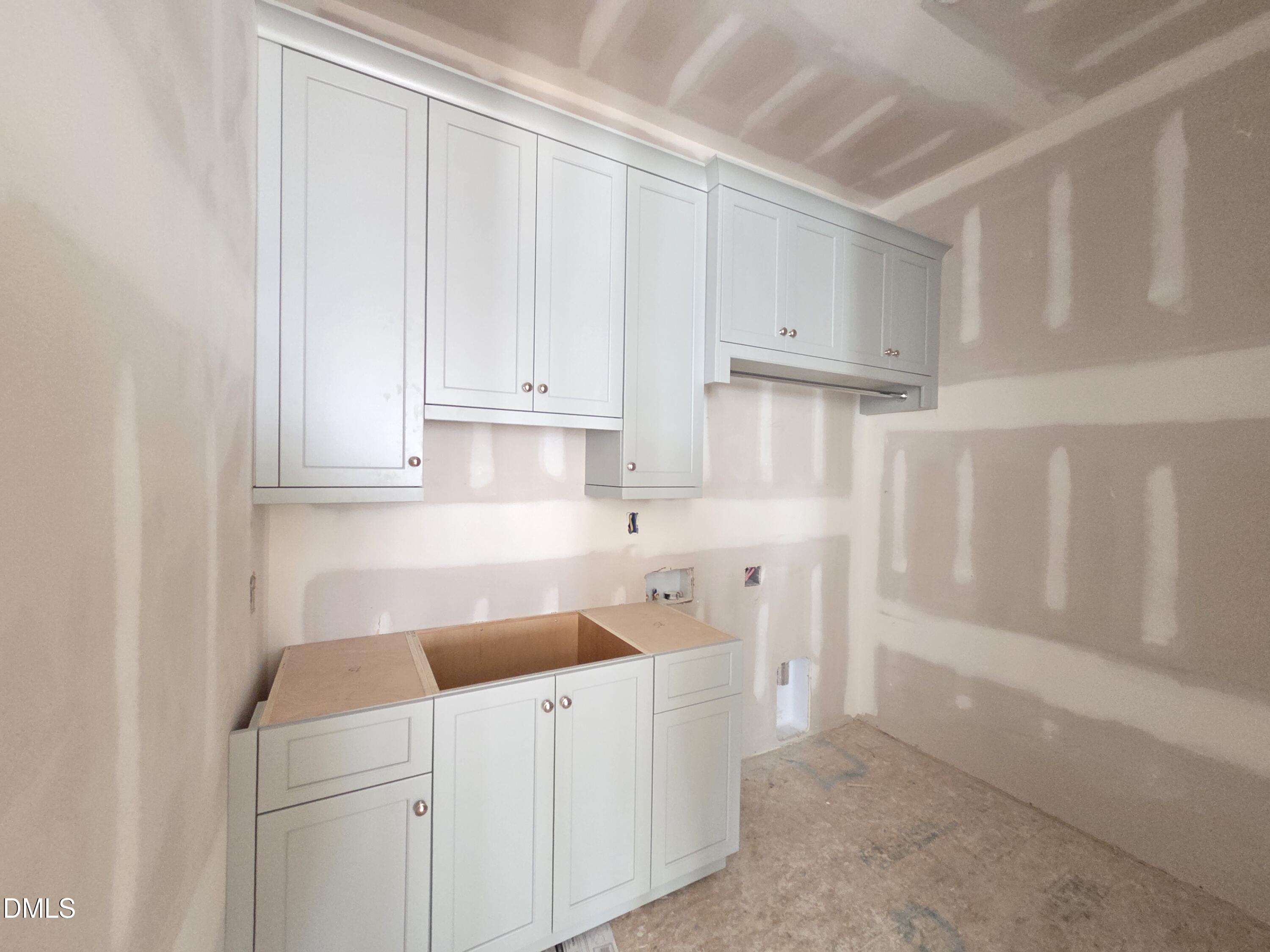 6477 Sanctuary Falls Drive Raleigh, NC 27614 - Photo 37 of 49 a kitchen with white cabinets and white appliances