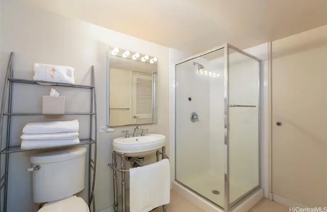 a bathroom with a sink a toilet and shower