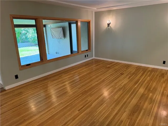 a view of a room with wooden floor and a window