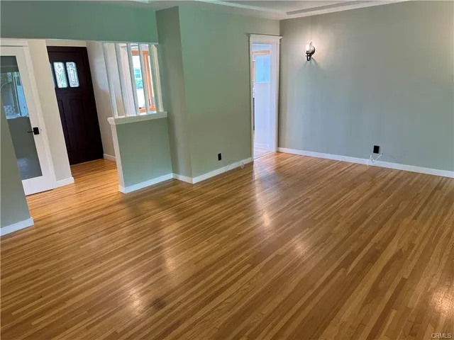 an empty room with wooden floor and door