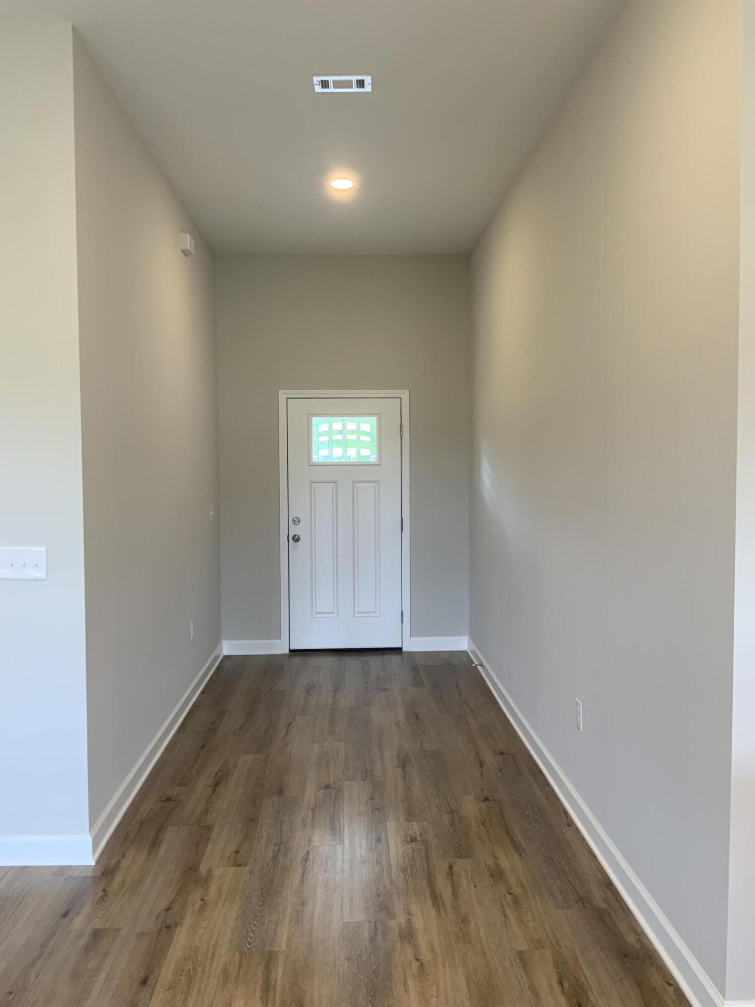 5235 Griffith Mill Road Baker, FL 32531 - Photo 2 of 10 an empty room with wooden floor and windows