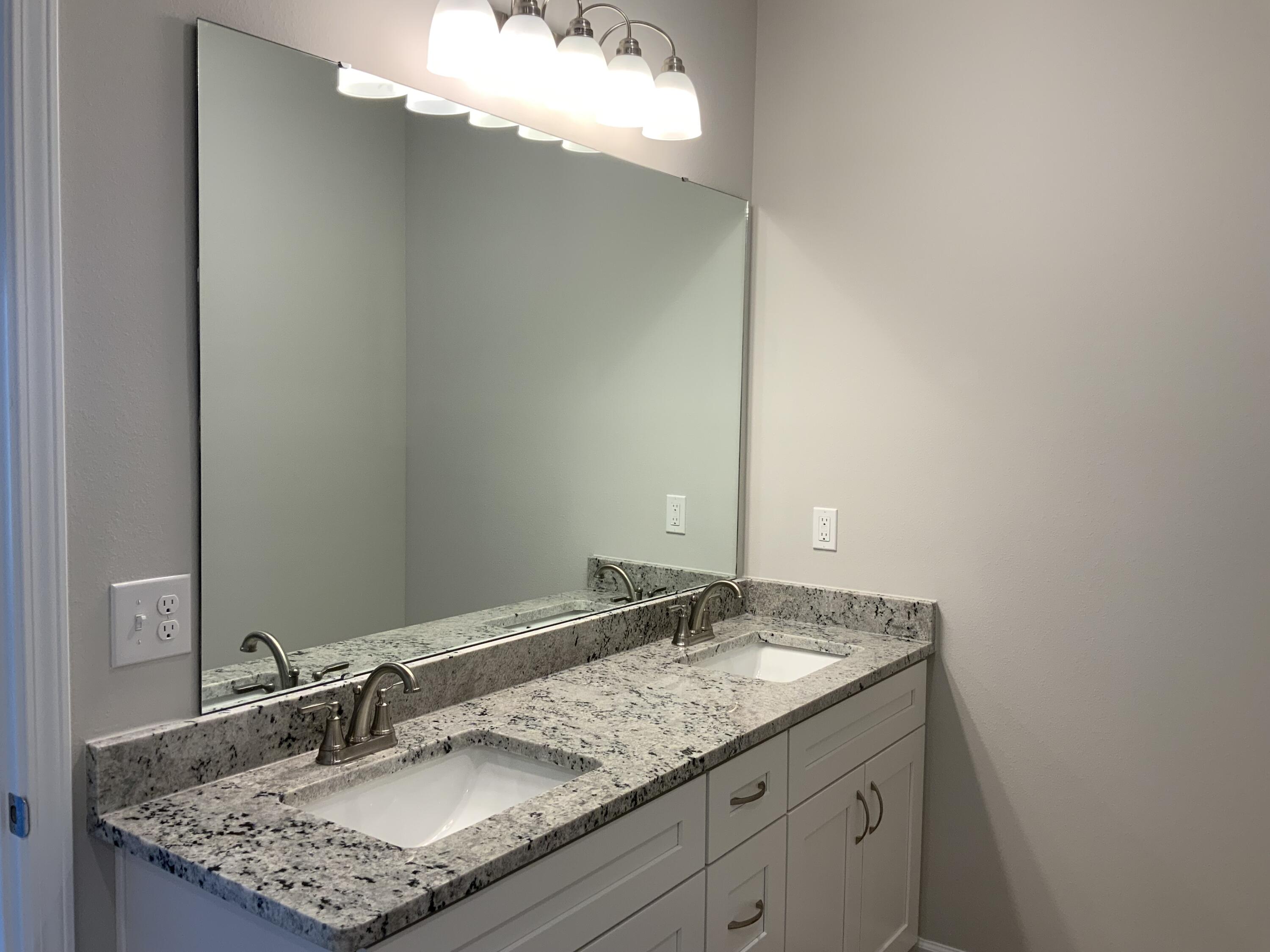5235 Griffith Mill Road Baker, FL 32531 - Photo 6 of 10 a bathroom with a granite countertop sink and a mirror