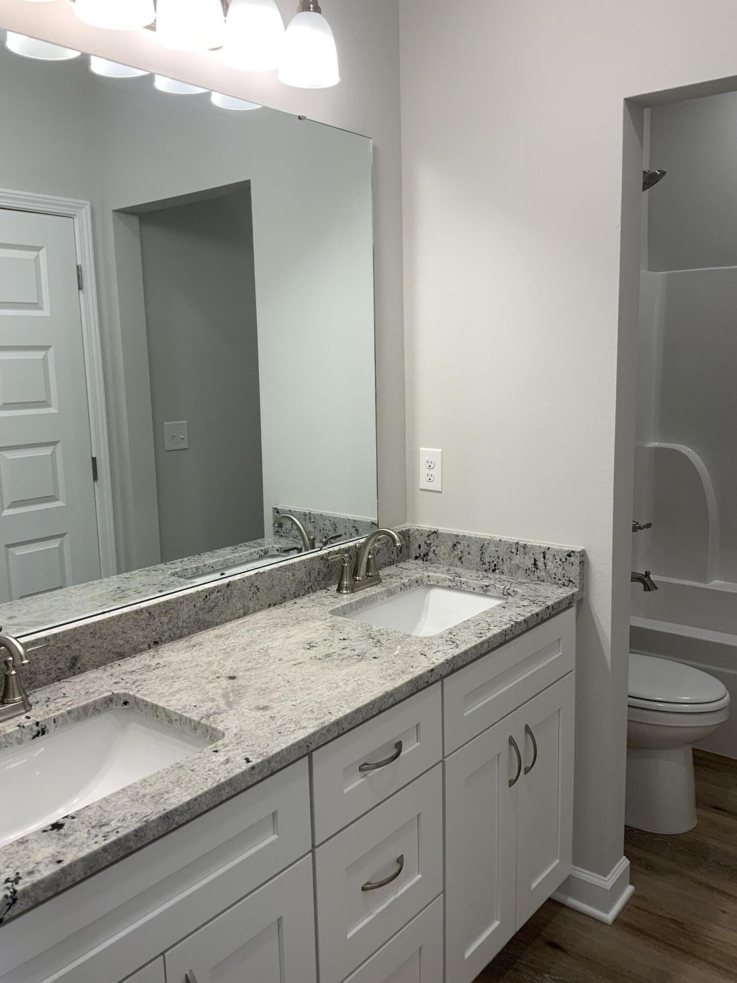 5235 Griffith Mill Road Baker, FL 32531 - Photo 8 of 10 a bathroom with a granite countertop sink and a mirror