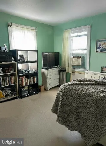 a spacious bedroom with a bed and a flat screen tv