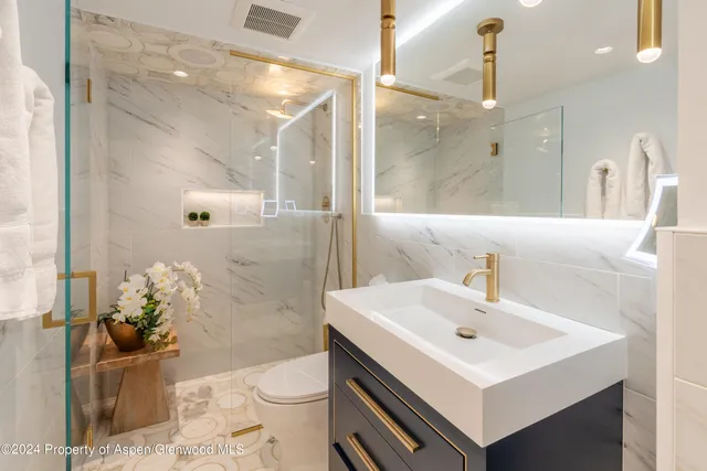 a bathroom with a sink toilet and shower