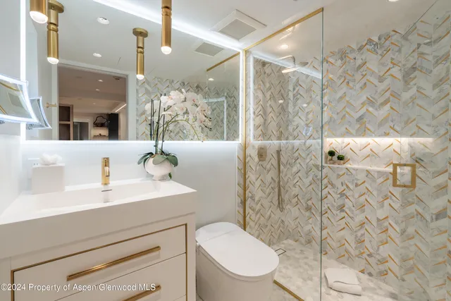 a bathroom with a sink mirror vanity and toilet