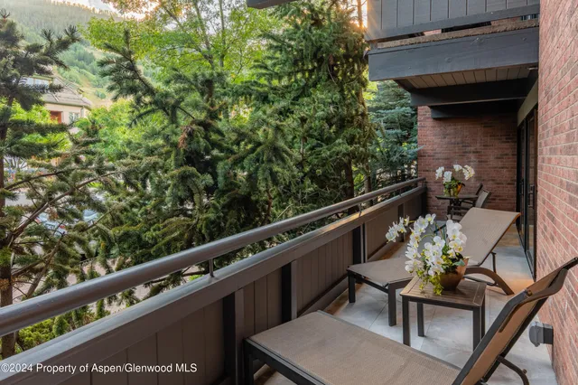 a balcony with wooden floor and outdoor seating