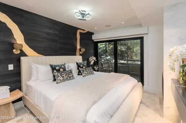 a large bed sitting in a bedroom next to a window