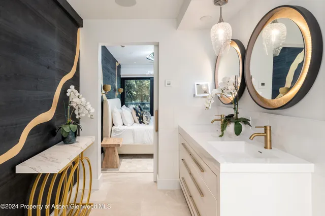 a en suite bathroom with a granite countertop sink and a mirror