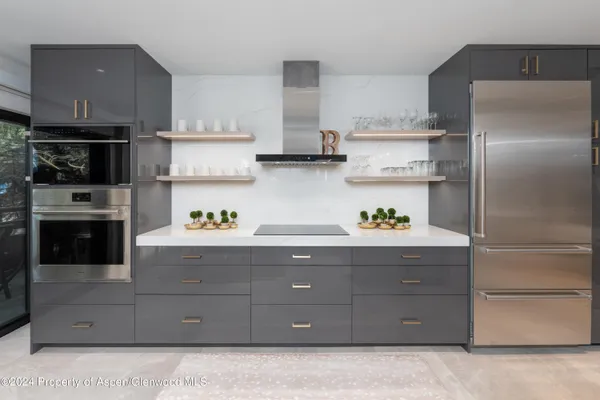 a kitchen with stainless steel appliances granite countertop a refrigerator and a stove