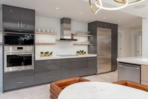 a kitchen with stainless steel appliances kitchen island granite countertop a refrigerator and a stove top oven