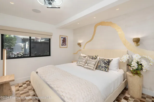 a bedroom with a bed and a painting on the wall