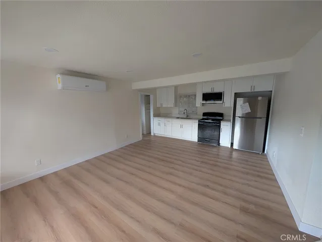 a view of a kitchen with a sink and a refrigerator